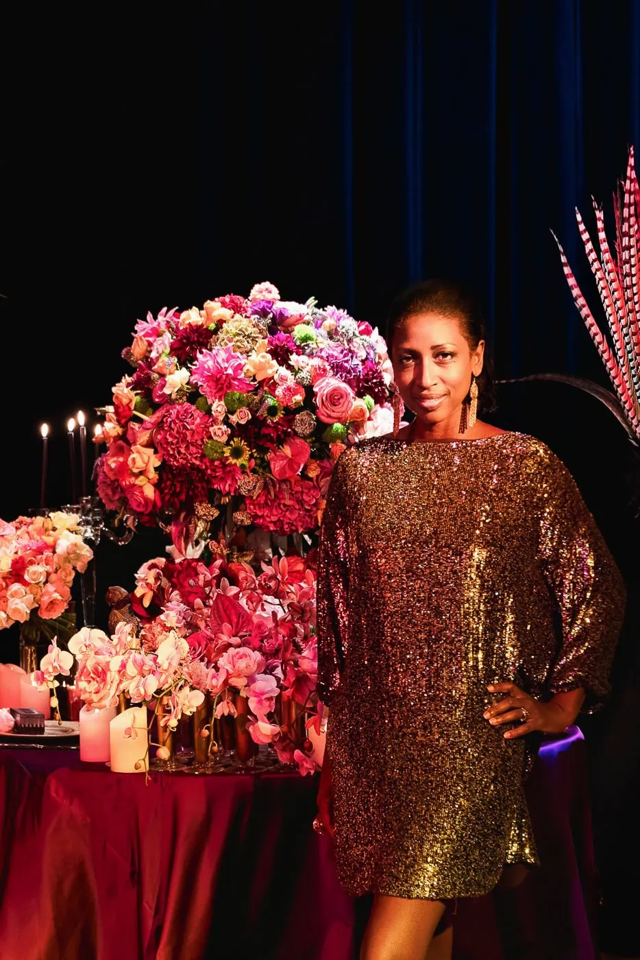 Chantelle STREETE, founder of Kiss Me in Paris Proposals & Weddings, in a golden gown beside a luxury floral installation she designed for a Paris wedding