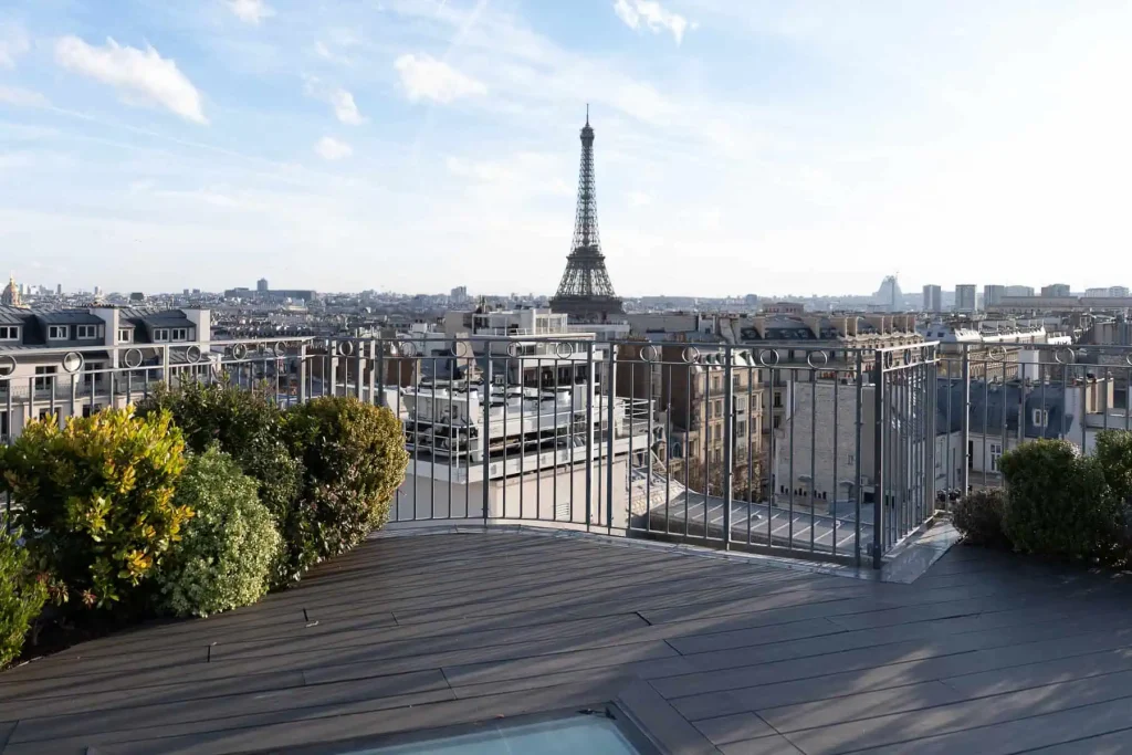 Empty private residential rooftop terrace in Paris with clear daytime Eiffel Tower view, shown before luxury proposal styling and production by Kiss Me in Paris.
