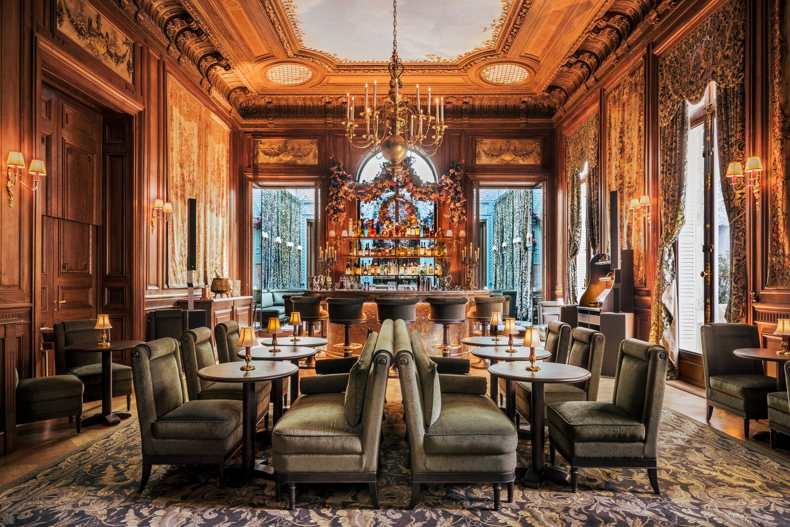 Baronne Paris restaurant opulent bar room with gilded wood panelling, chandelier and green velvet armchairs