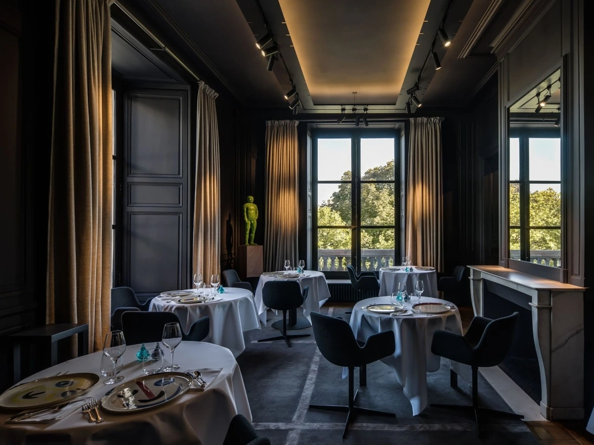Guy Savoy Paris restaurant intimate dark dining room with contemporary art, sculptural chairs and garden views at the Monnaie de Paris