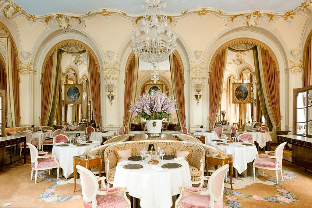 L'Espadon restaurant at Ritz Paris opulent dining room with gilded mouldings, pink velvet chairs, arched mirrors and crystal chandelier
