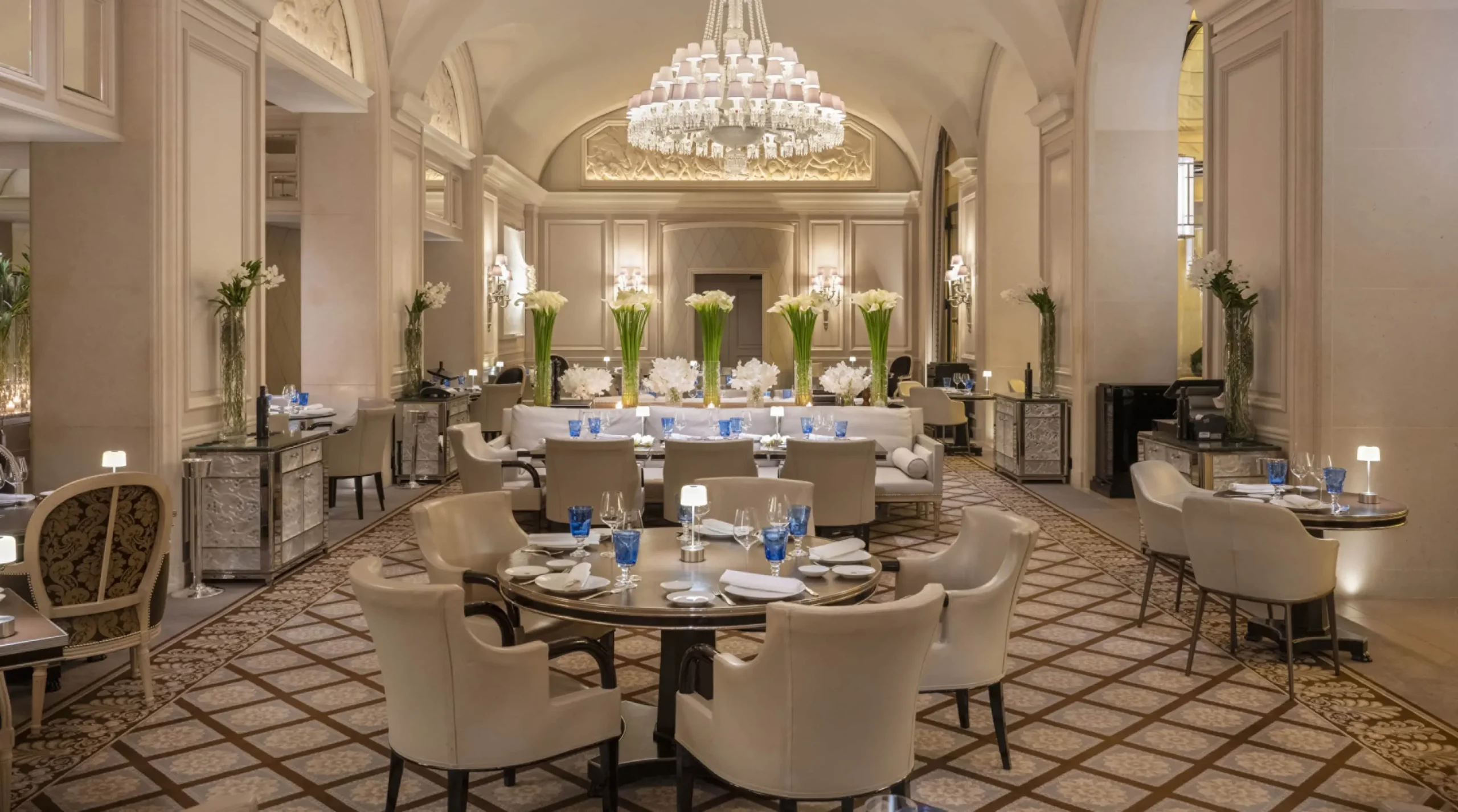 Le George restaurant at Four Seasons George V Paris refined dining room with vaulted ceiling, tiered chandelier and blue glassware