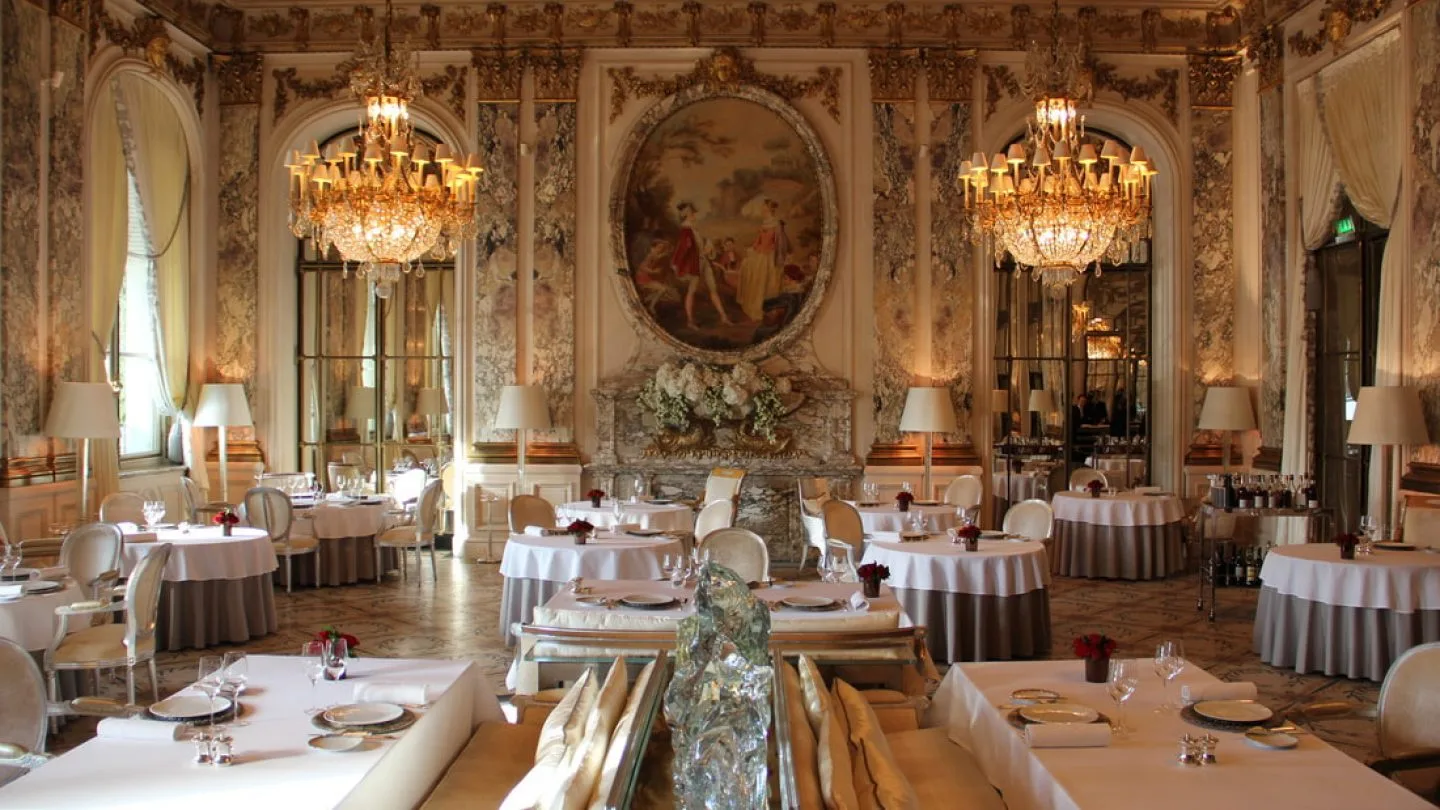 Le Meurice Alain Ducasse Paris restaurant royal dining room with gilded rococo mouldings, crystal chandeliers and oval ceiling painting