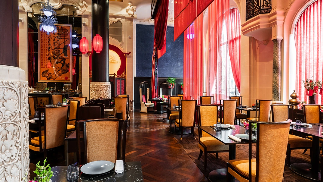 Lili restaurant at The Peninsula Paris dramatic Chinese dining room with red lanterns, scarlet drapes and herringbone parquet floor