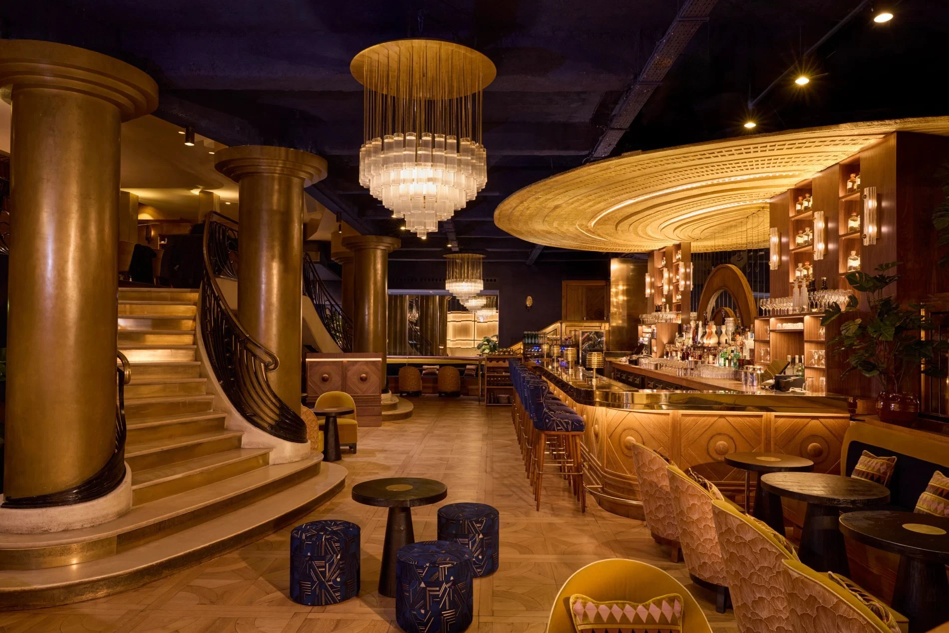 Manko Paris restaurant glamorous Art Deco bar with grand staircase, brass columns and tiered chandelier