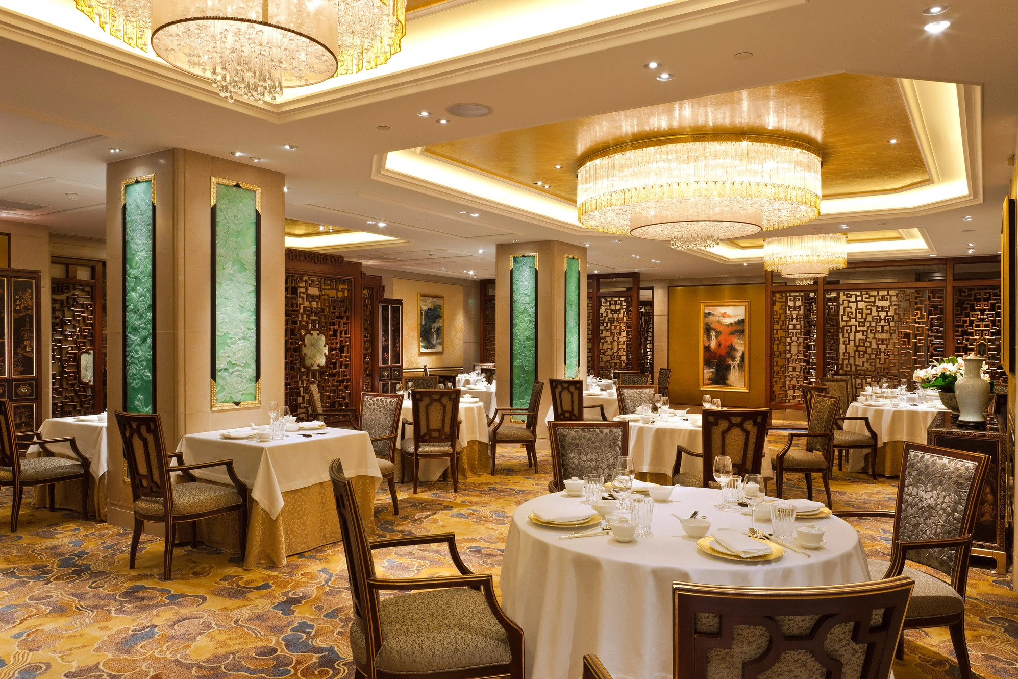 Shang Palace Paris restaurant opulent Chinese dining room with jade green panels, crystal chandeliers and carved wooden screens