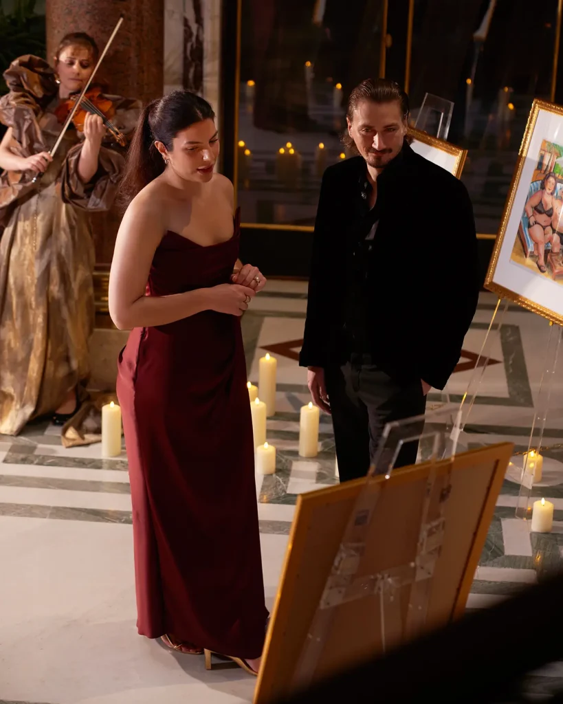 Couple standing together with live violinist playing behind them, candlelit gallery at Musée Jacquemart-André