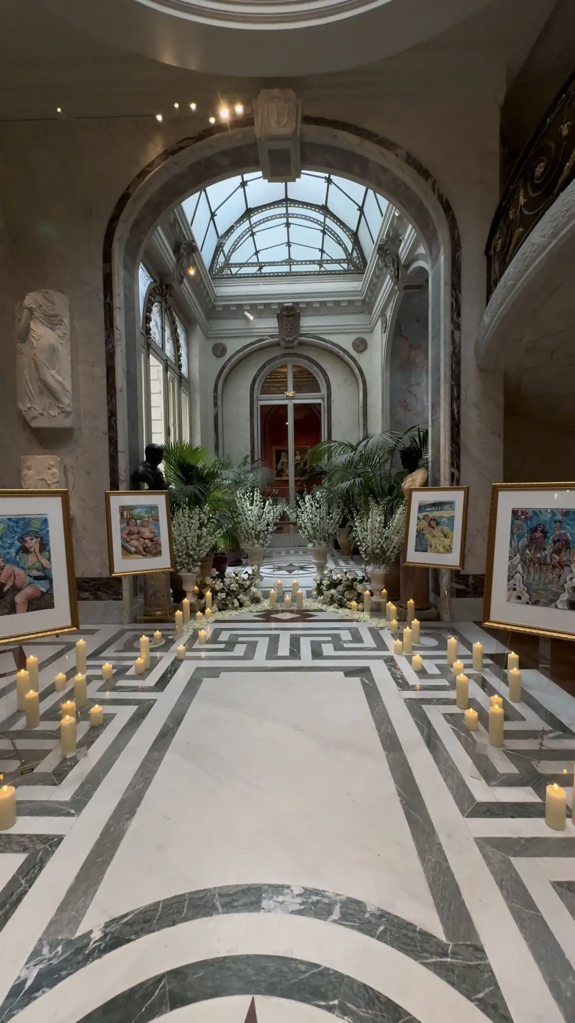 Candlelit marble aisle with florals and framed artwork set up for a proposal at Musée Jacquemart-André