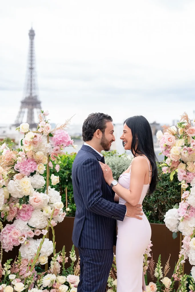 Engaged couple laughing face to face on The Peninsula Paris rooftop with Eiffel Tower in the background