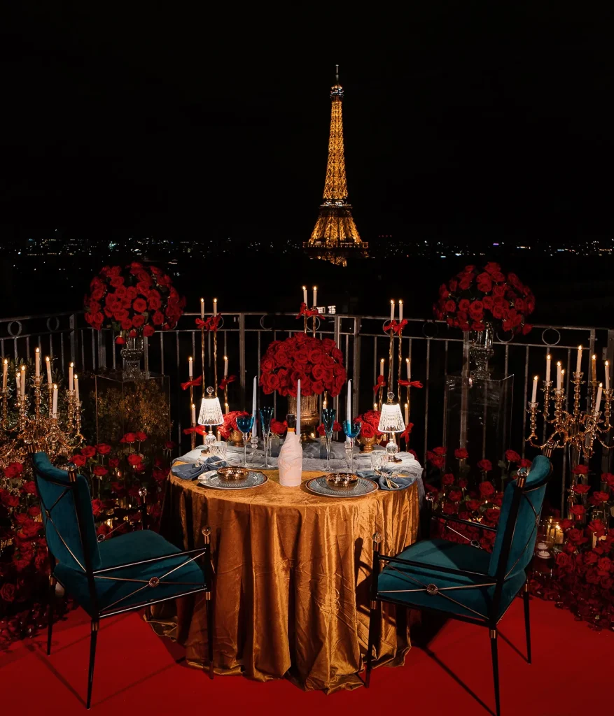 Gold-draped dinner table for two on a Paris rooftop with Eiffel Tower and city skyline