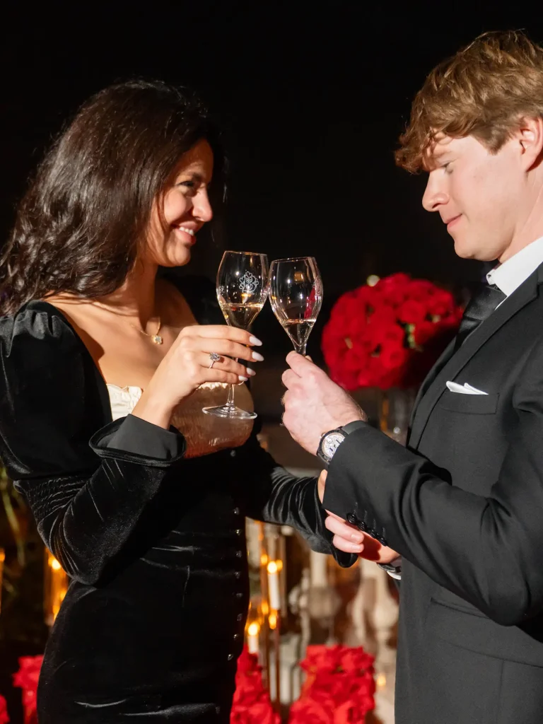 Couple toasting with champagne glasses close-up on The Shangri-La Paris rooftop with Eiffel Tower view