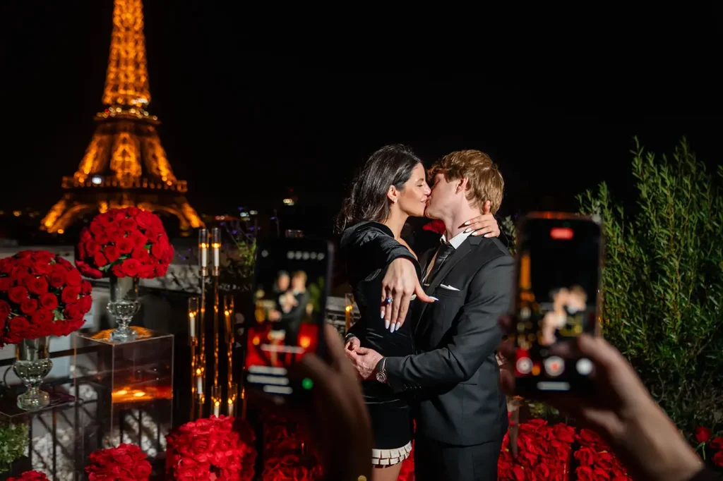 Newly engaged couple kissing on The Shangri-La Paris rooftop with Eiffel Tower view