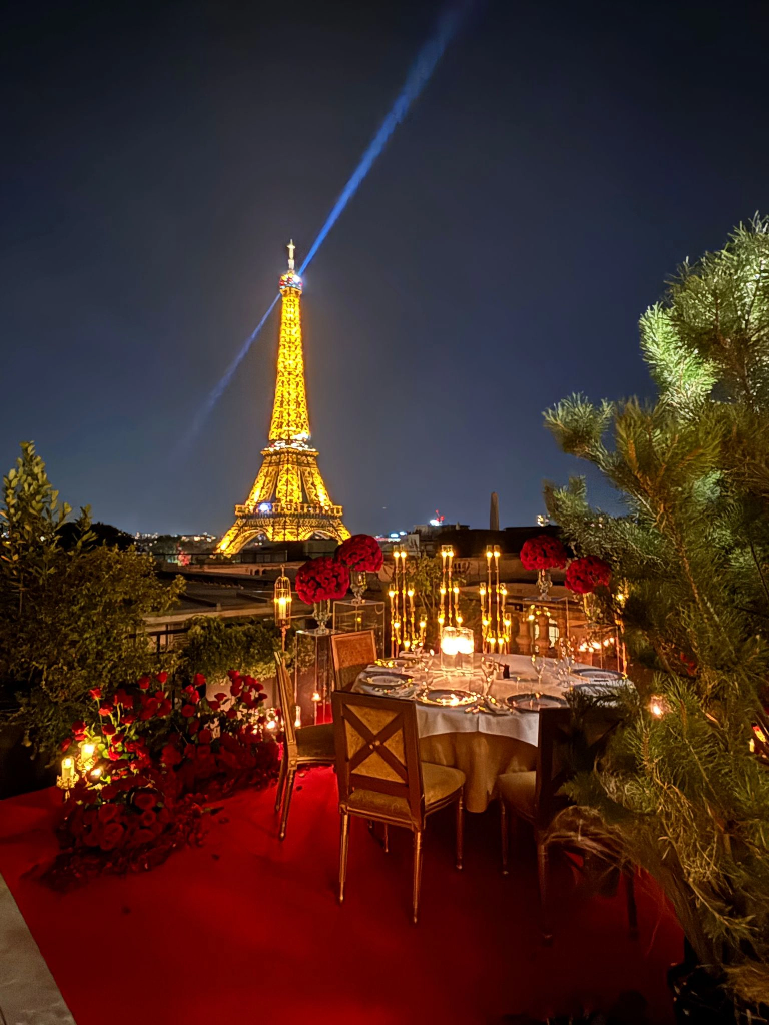 Candlelit dinner table set on The Shangri-La Paris rooftop with Eiffel Tower view