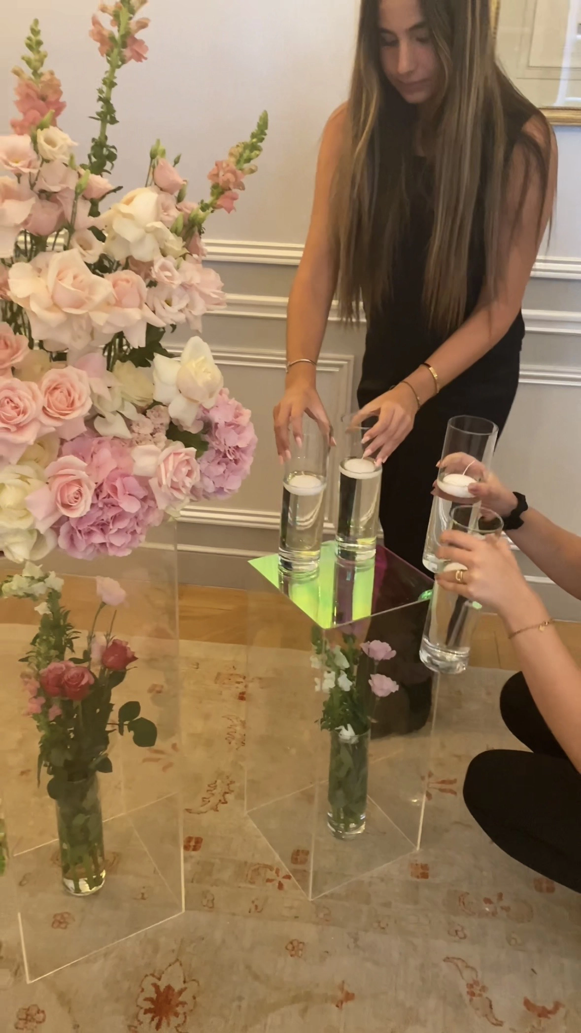 Florist arranging floating candles in glass vases during proposal decor setup at Le Bristol Paris