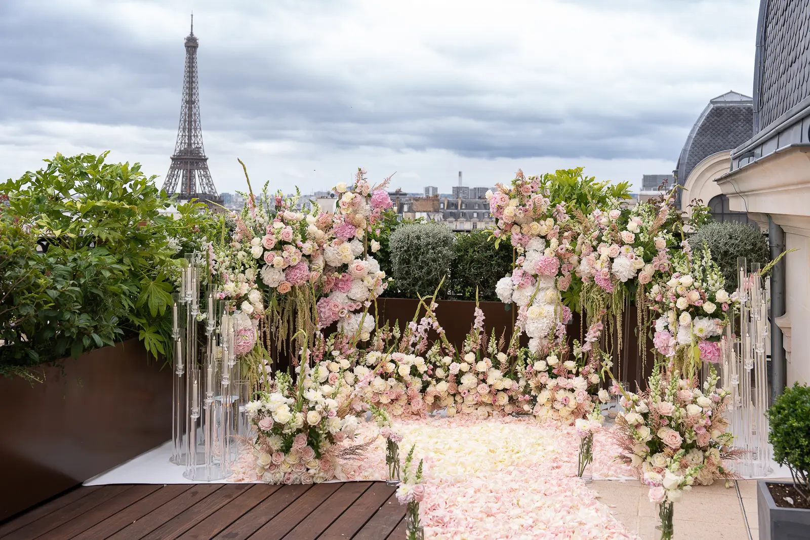 Pink and ivory floral proposal arch on The Peninsula Paris rooftop with Eiffel Tower in background
