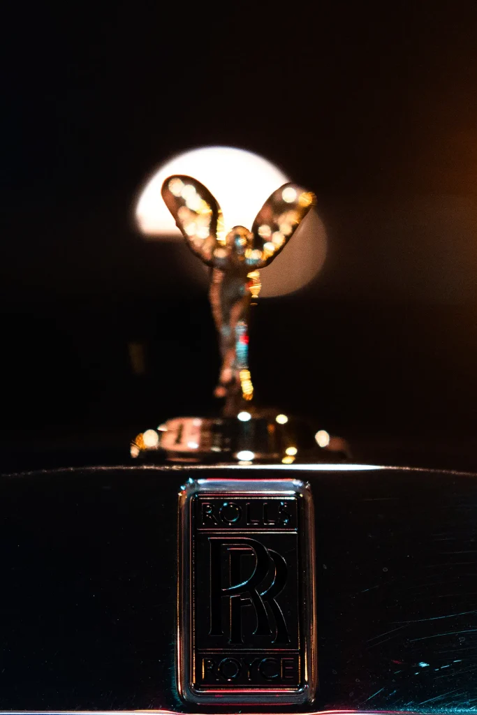 Close-up of the Rolls-Royce Spirit of Ecstasy hood ornament and badge at night