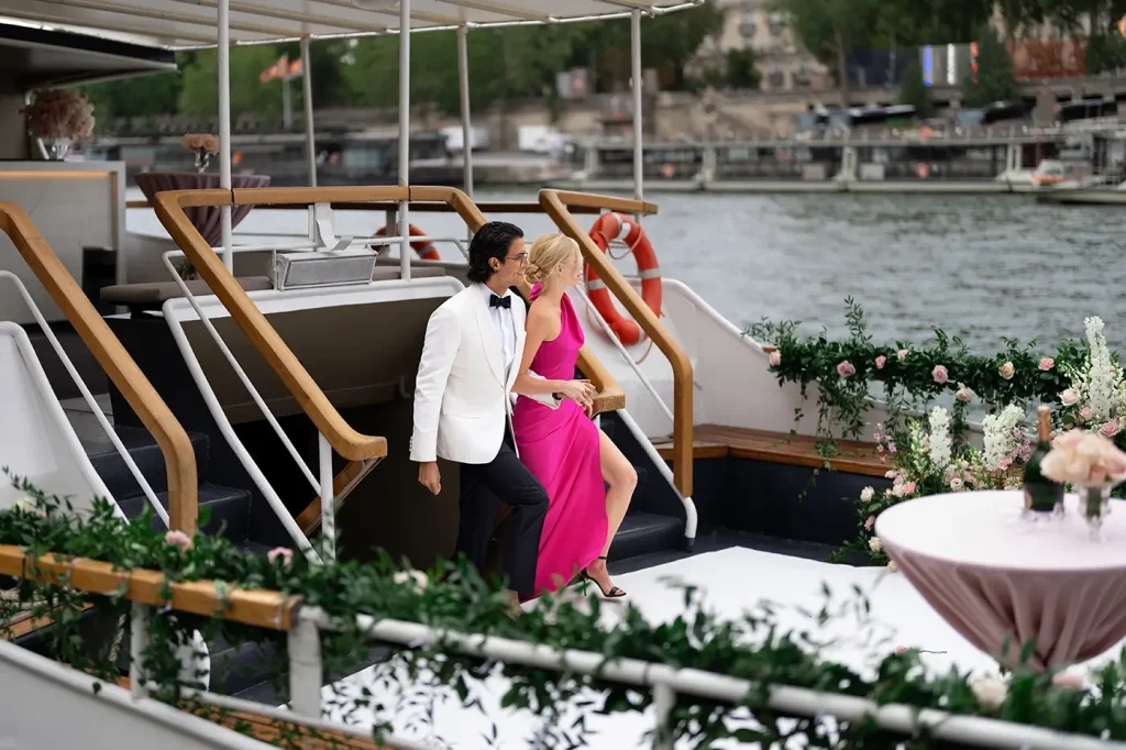 Couple walking down the stairs onto the decorated deck of a private Seine yacht in Paris
