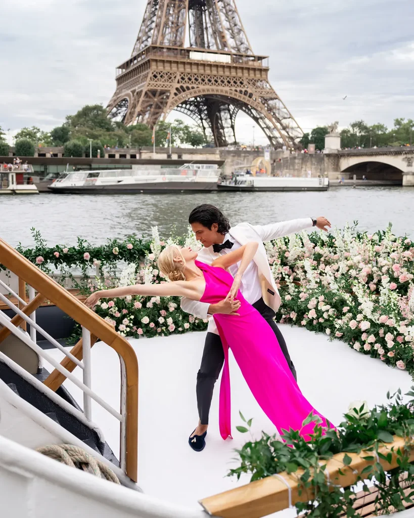 Couple dancing on a private Seine yacht with the full Eiffel Tower directly behind them