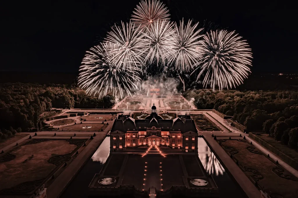Aerial view of fireworks above Château de Vaux-le-Vicomte during a private proposal celebration.