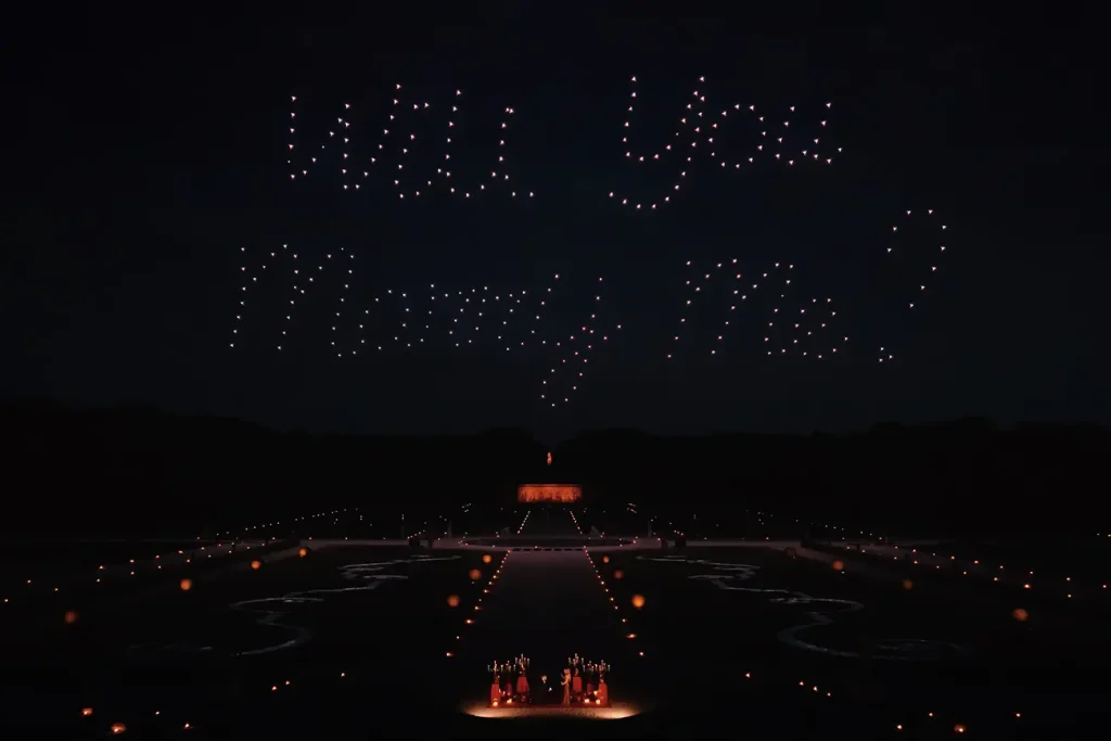 Drone light show spelling "Will You Marry Me" above the gardens of Château de Vaux-le-Vicomte at night