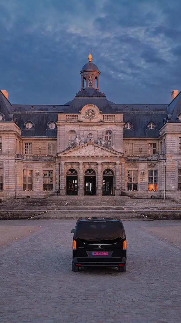 Private car arriving at Château de Vaux le Vicomte at dusk for a proposal, candlelit steps to the entrance