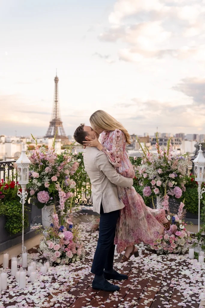 Private rooftop proposal at The Peninsula Paris with Eiffel Tower view, couple embracing beneath a floral arch at dusk