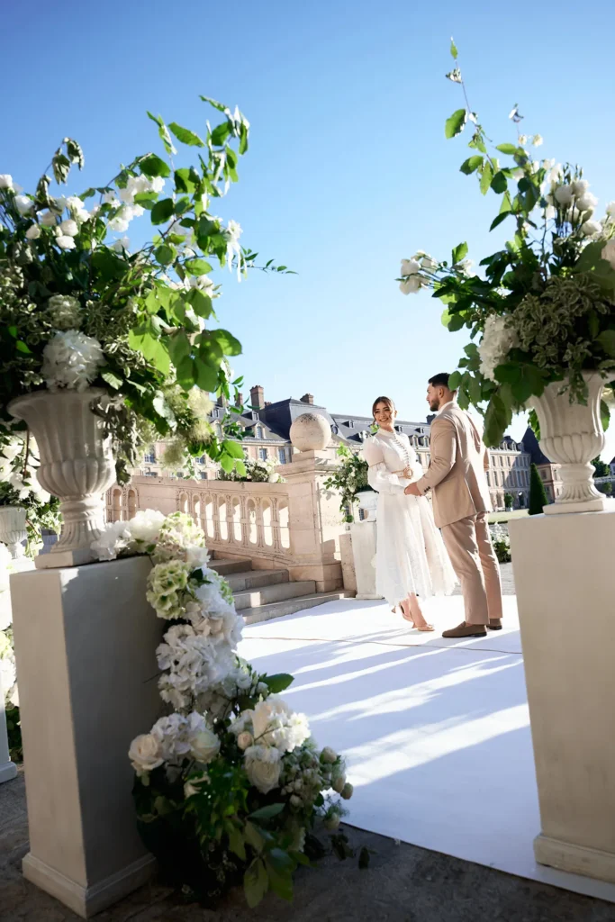 Couple standing on a flower-lined terrace at Château de Fontainebleau