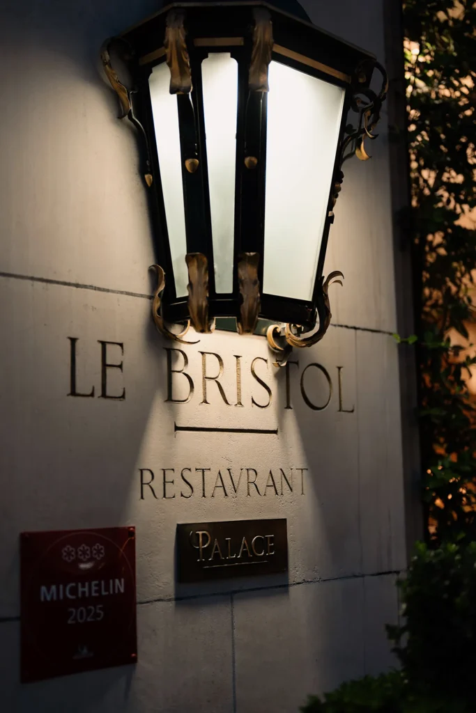 Le Bristol Paris exterior with its illuminated entrance and Palace designation