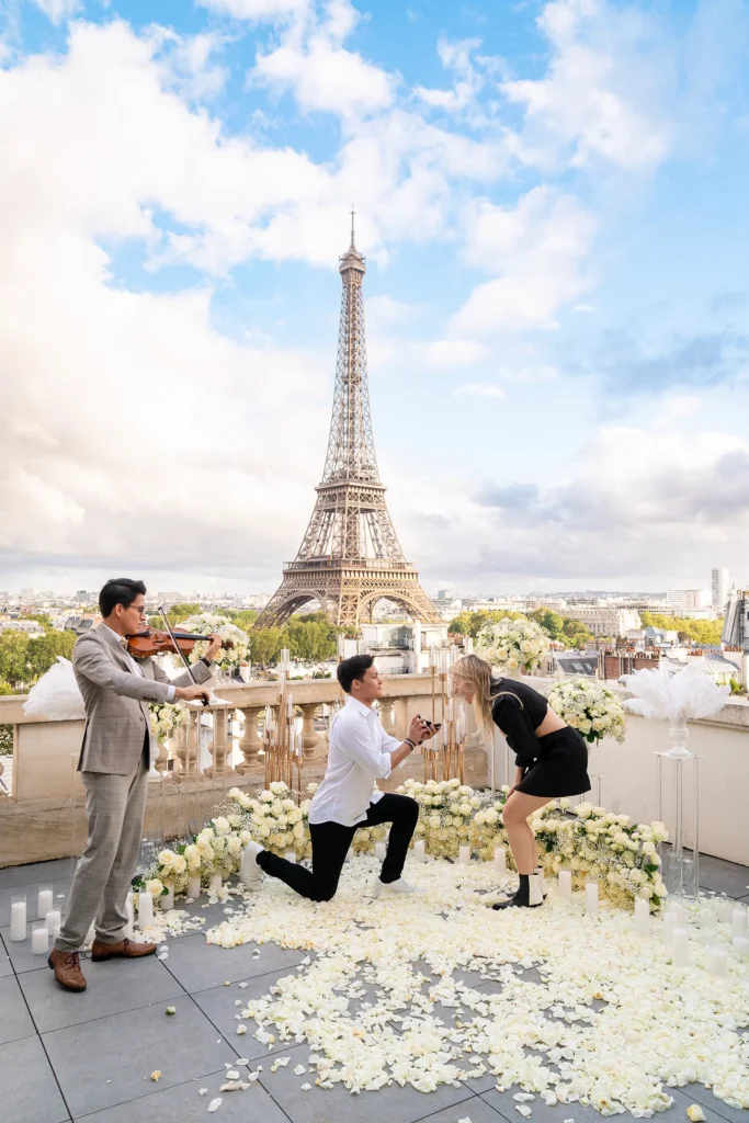 Man proposing to his partner with a violinist beside the Eiffel Tower in Paris