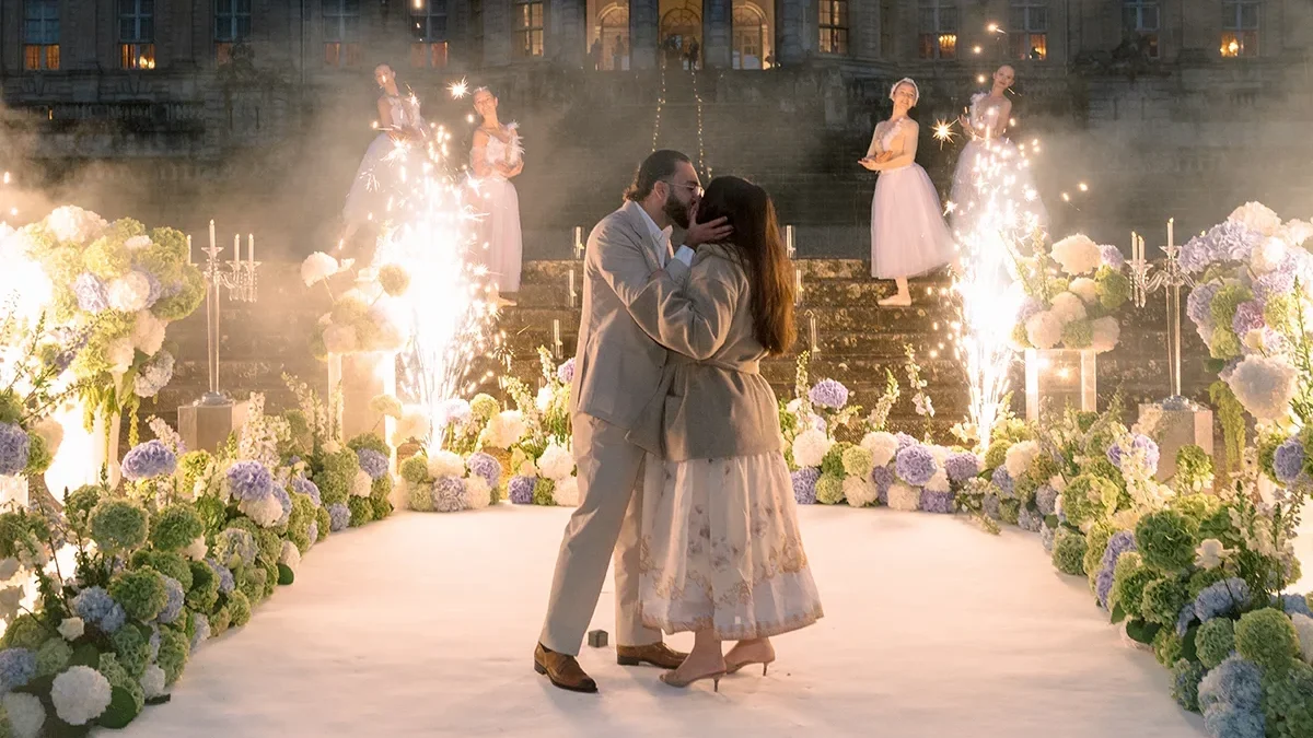 Couple kisses after proposal at Château de Vaux-le-Vicomte with ballerinas and firework fountains