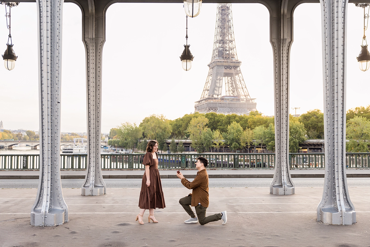 Public proposal at Bir-Hakeim with man kneeling before his partner and the Eiffel Tower in the background