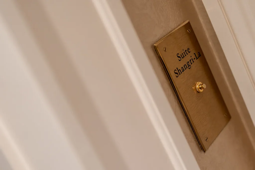 Brass door plaque engraved with Suite Shangri La outside the room where the proposal was planned in Paris